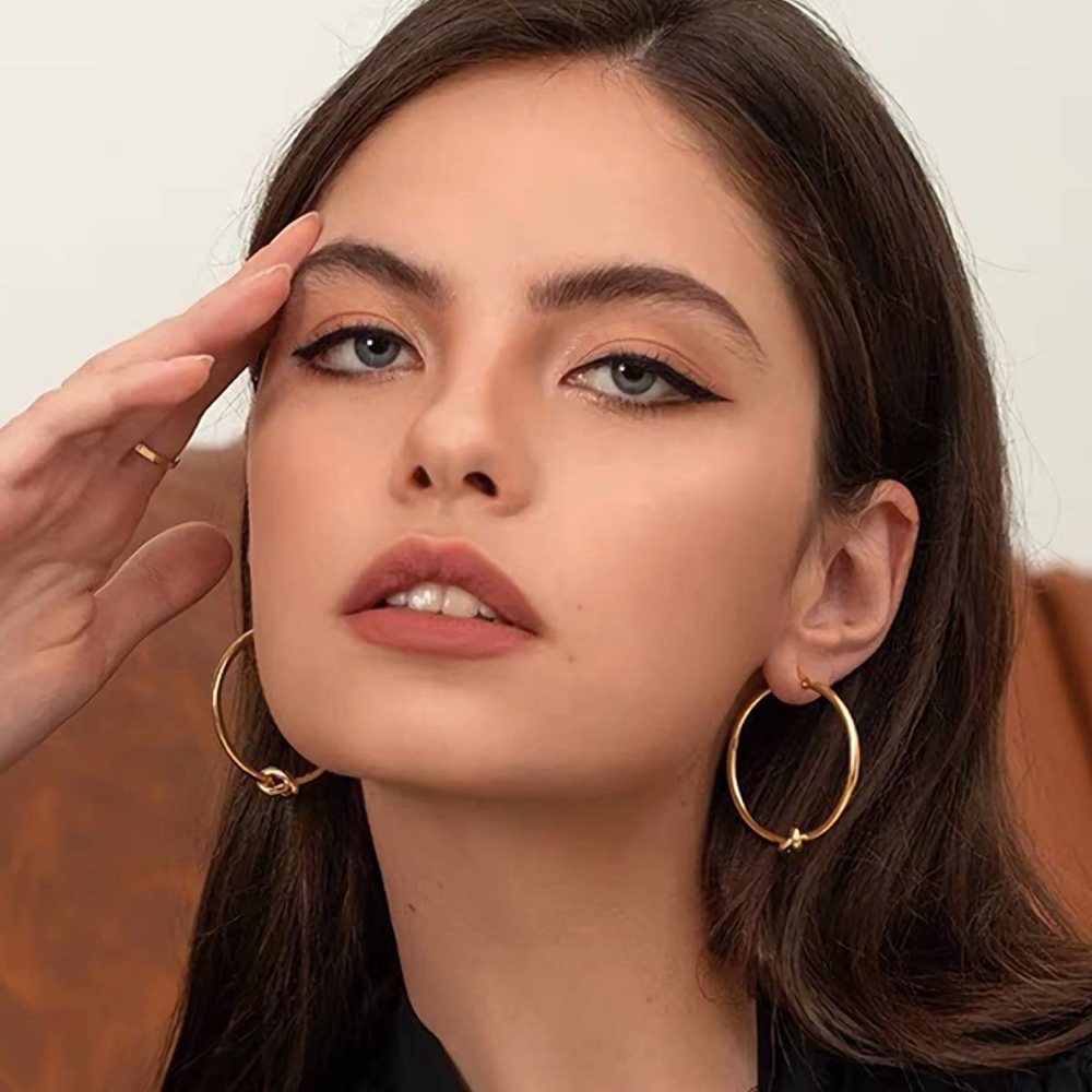 YUJIE gold knot hoop earrings worn close-up
