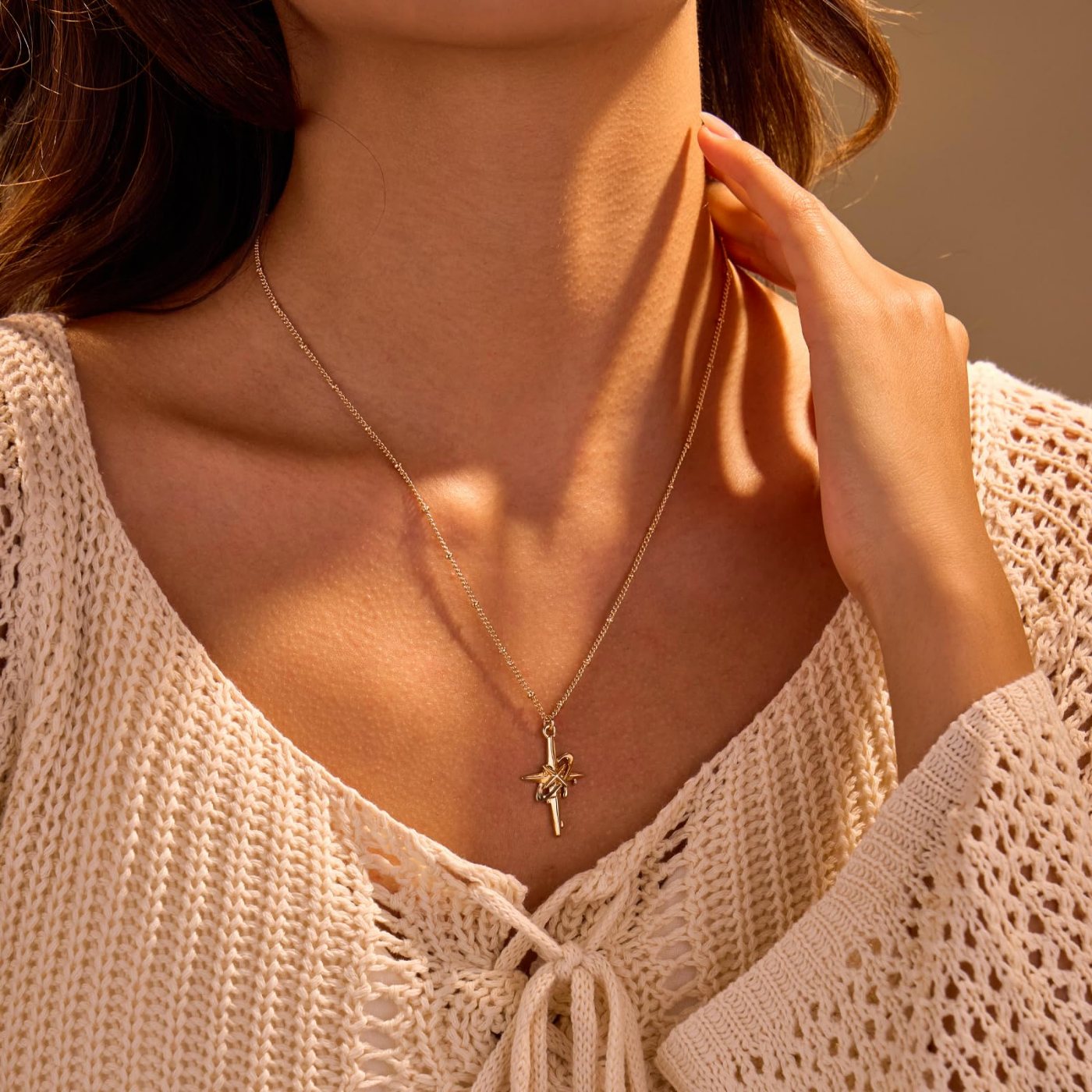 YUJIE cross star pendant necklace worn with a knit top